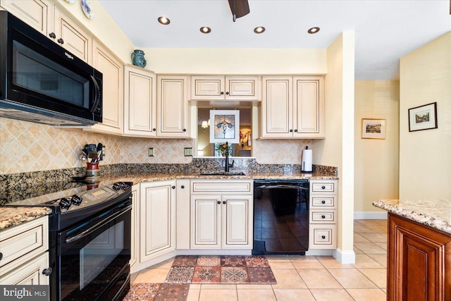 kitchen with a sink, cream cabinetry, black appliances, and light tile patterned floors