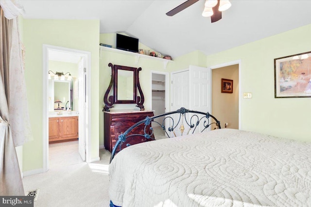 bedroom with light carpet, ensuite bathroom, a closet, lofted ceiling, and ceiling fan