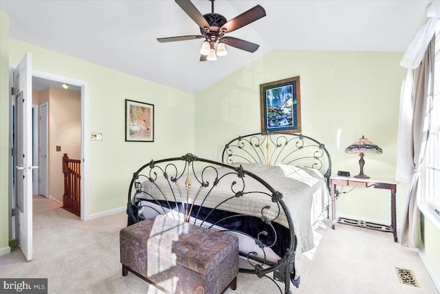 carpeted bedroom featuring visible vents, lofted ceiling, multiple windows, and baseboards