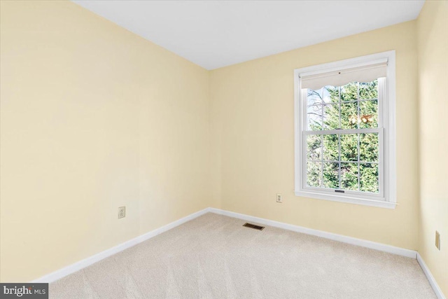 empty room with visible vents, baseboards, carpet, and a healthy amount of sunlight