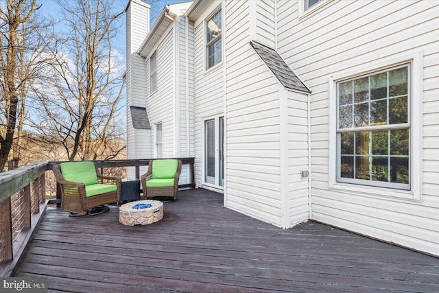 deck with central AC unit and a fire pit