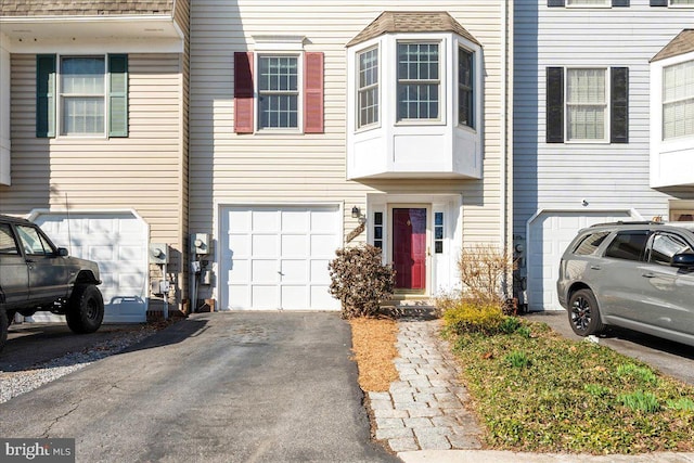 townhome / multi-family property featuring driveway and a garage