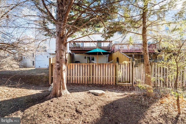 back of house featuring a deck and fence