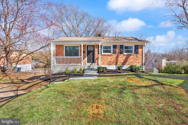 view of front of house with a front lawn, covered porch, and brick siding