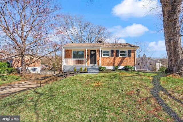 view of front of home featuring brick siding, covered porch, and a front lawn