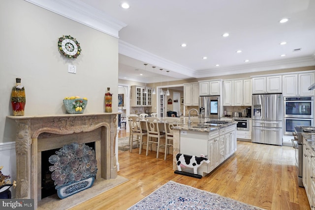 kitchen featuring a large island, light stone countertops, light wood-type flooring, and stainless steel appliances