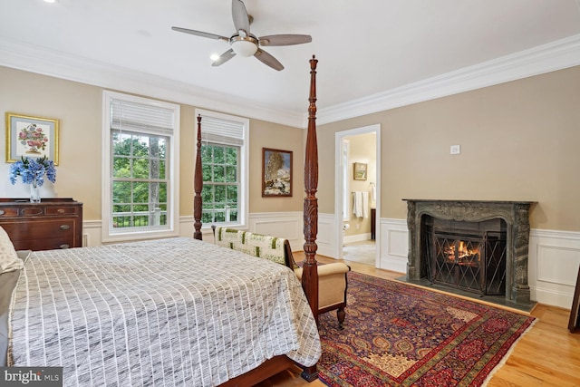 bedroom featuring a fireplace, wood finished floors, and ornamental molding