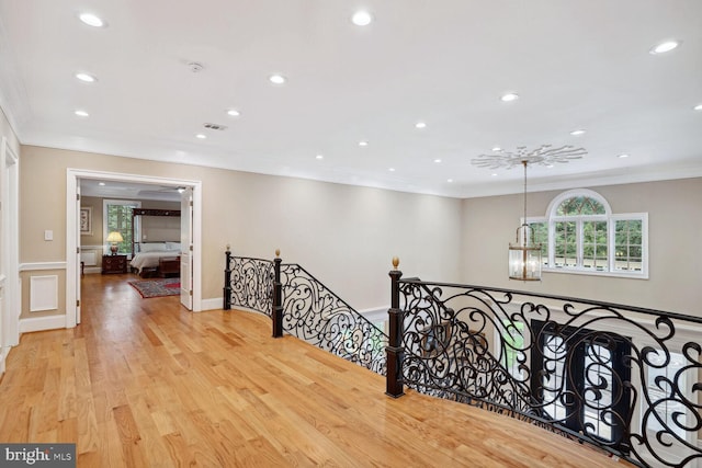 hall featuring visible vents, crown molding, an upstairs landing, recessed lighting, and wood finished floors