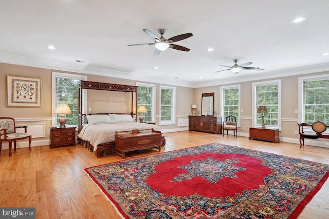 bedroom featuring visible vents, multiple windows, crown molding, and light wood-style floors