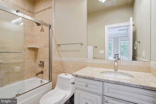 full bathroom with visible vents, tile walls, toilet, shower / bath combination, and vanity