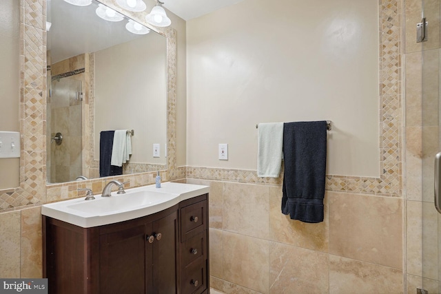 bathroom featuring a stall shower, tile walls, and vanity