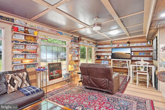 living room featuring coffered ceiling and wood finished floors