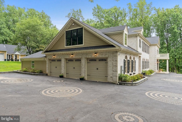 view of front of property with brick siding, an attached garage, aphalt driveway, and roof with shingles