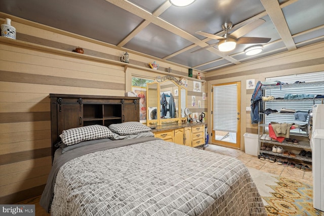 bedroom featuring wooden walls and coffered ceiling