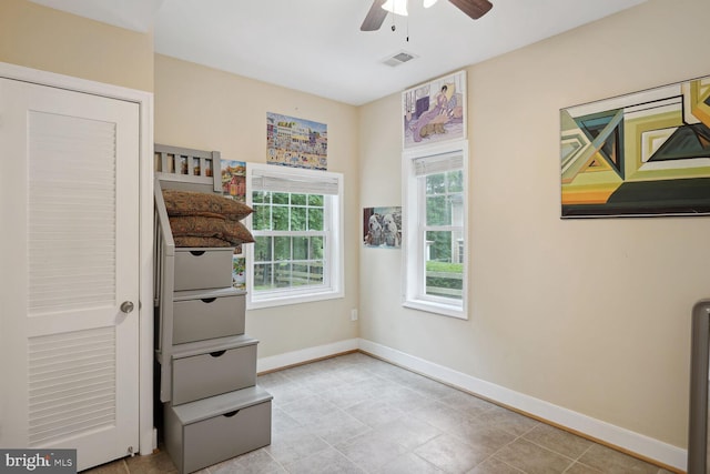 interior space featuring visible vents, baseboards, and ceiling fan