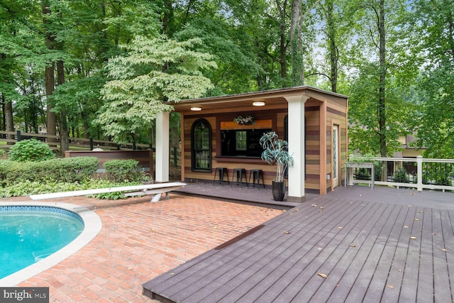 outdoor pool featuring an outdoor structure and a deck