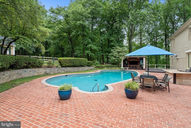 pool featuring a gazebo, a patio, area for grilling, and fence