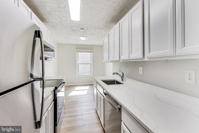 kitchen with white cabinets, appliances with stainless steel finishes, and a sink