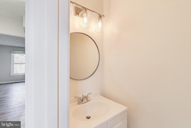 bathroom featuring a textured ceiling, wood finished floors, and vanity