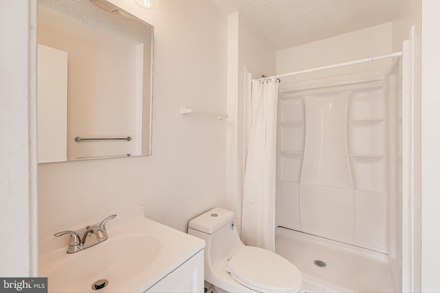 bathroom with toilet, a stall shower, vanity, and a textured ceiling