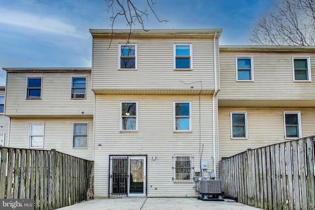 rear view of property with a patio, central AC unit, and a fenced backyard