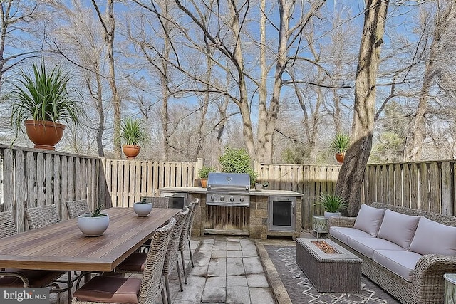 view of patio / terrace with an outdoor kitchen, area for grilling, outdoor dining area, a fenced backyard, and an outdoor hangout area