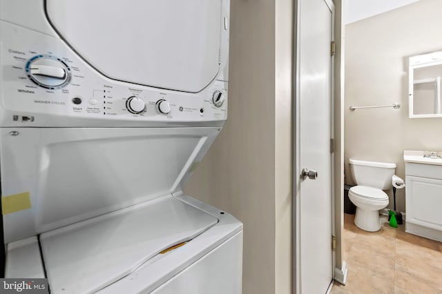 clothes washing area with laundry area and stacked washing maching and dryer