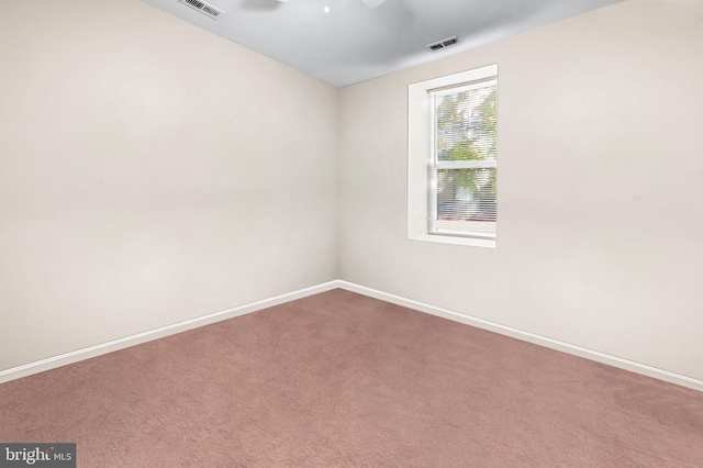 unfurnished room with carpet flooring, visible vents, and baseboards