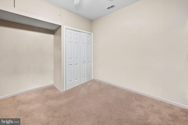 unfurnished bedroom featuring visible vents, ceiling fan, baseboards, carpet floors, and a closet