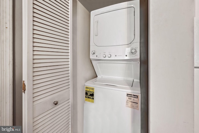 washroom with stacked washer and clothes dryer and laundry area