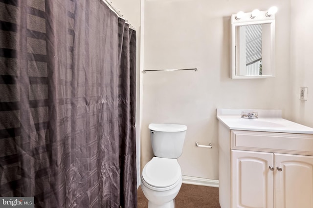 bathroom with toilet, curtained shower, vanity, and baseboards