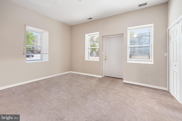 carpeted spare room with baseboards and visible vents