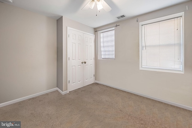 unfurnished bedroom featuring a closet, baseboards, visible vents, and carpet flooring