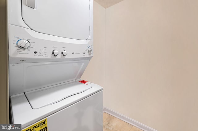 washroom featuring laundry area, baseboards, and stacked washing maching and dryer