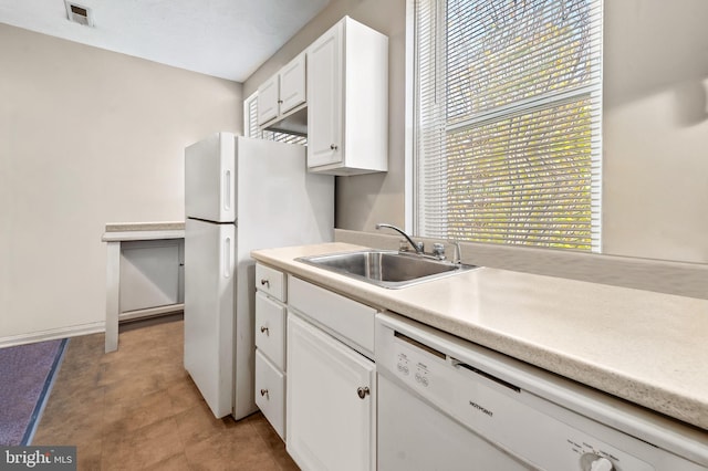 kitchen with visible vents, light countertops, white appliances, white cabinetry, and a sink