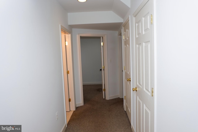 corridor featuring baseboards and carpet floors