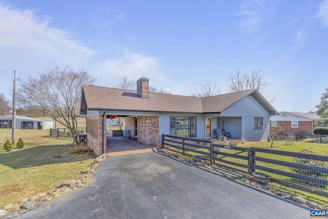 ranch-style house with a fenced front yard, a chimney, and a front lawn