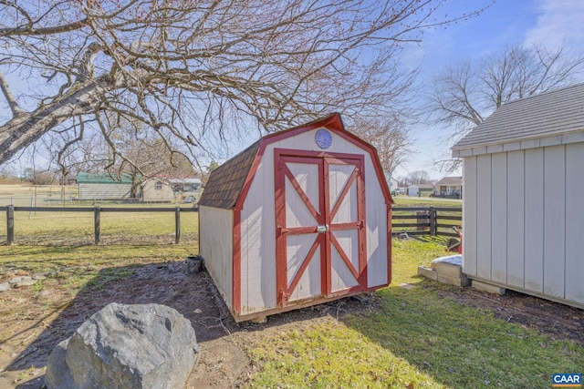 view of shed featuring a rural view and fence