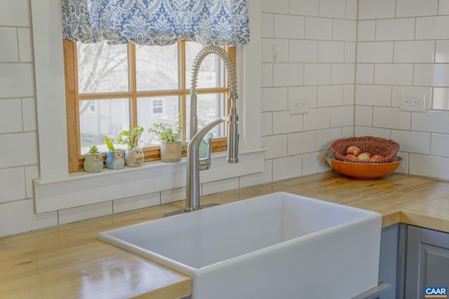 interior details with a sink, wood counters, and tasteful backsplash