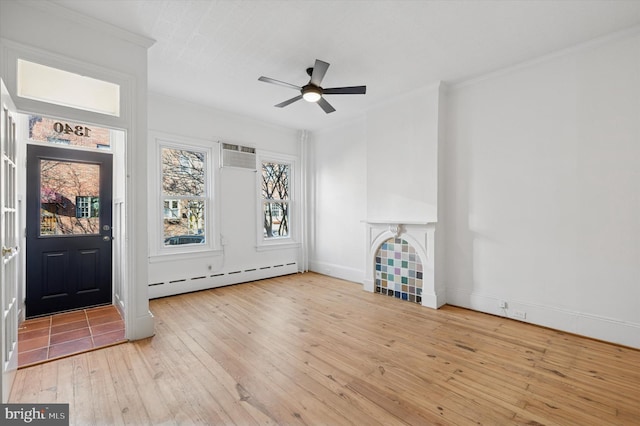 interior space featuring ornamental molding, a baseboard heating unit, wood-type flooring, baseboards, and a tile fireplace