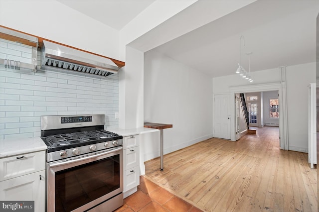 kitchen with tasteful backsplash, range hood, light wood-style floors, white cabinets, and gas stove