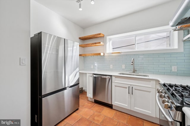 kitchen featuring a sink, tasteful backsplash, white cabinetry, appliances with stainless steel finishes, and light countertops