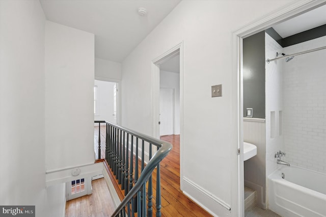 hallway featuring wood finished floors and an upstairs landing