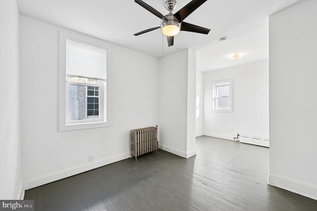 spare room featuring baseboards, baseboard heating, dark wood finished floors, and radiator heating unit