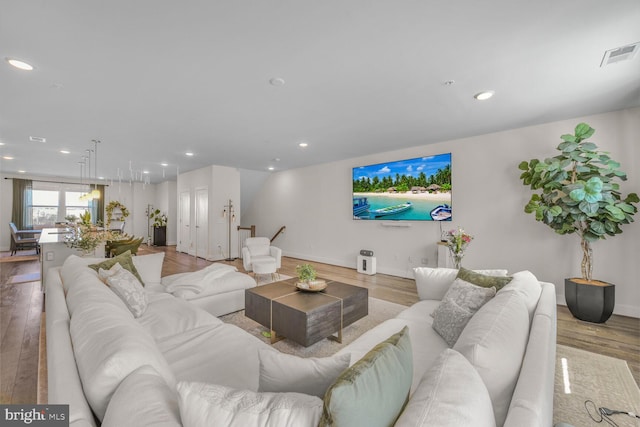 living room with recessed lighting, wood finished floors, visible vents, and baseboards