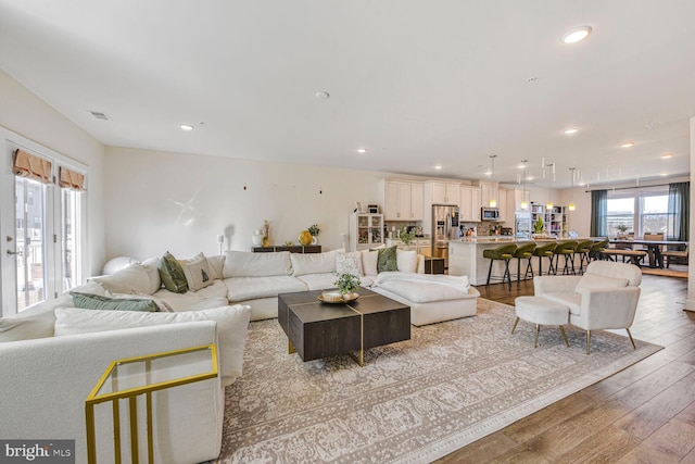 living room featuring recessed lighting, visible vents, and light wood-style floors