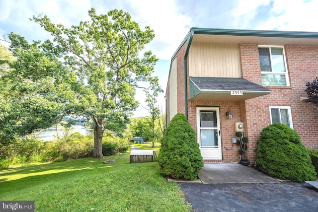 townhome / multi-family property featuring brick siding and a front lawn