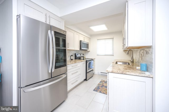 kitchen with a sink, stainless steel appliances, tasteful backsplash, and white cabinetry