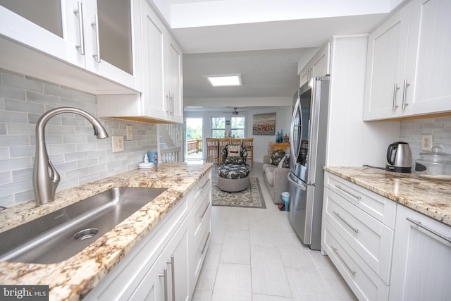 kitchen with ceiling fan, smart refrigerator, white cabinetry, and a sink