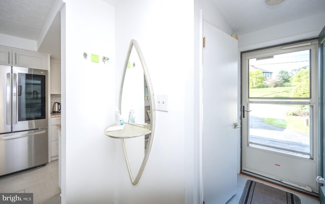 doorway to outside with a textured ceiling